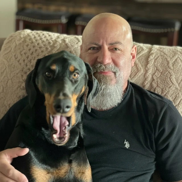 Shaun Lopez sitting with his dog on a couch.